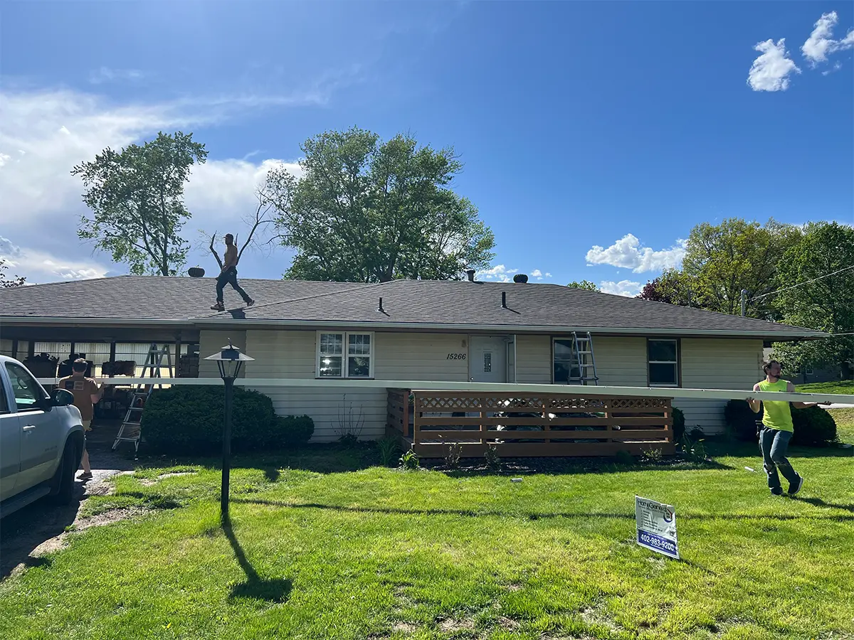 Updated exterior of a single-story home after renovations, featuring a clean and maintained yard and new siding, under clear skies.