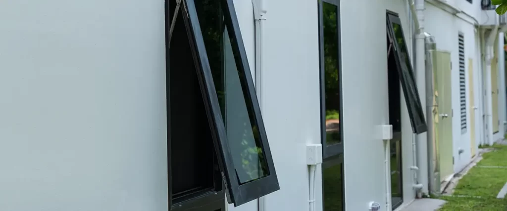 Black-framed awning windows on a white commercial building