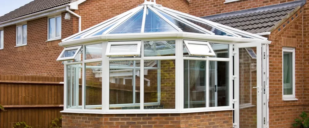 Brick house with glass conservatory featuring large windows