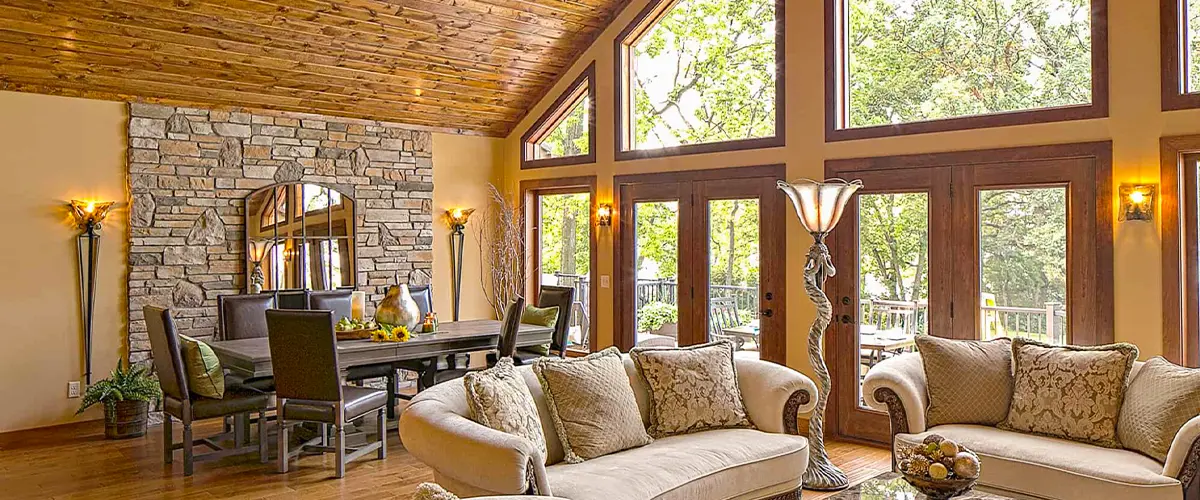 Elegant living room with large custom windows, wooden ceilings, and modern decor.