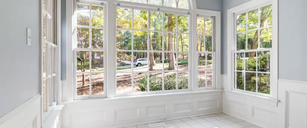 Spacious sunroom with classic white-framed windows and a scenic outdoor view