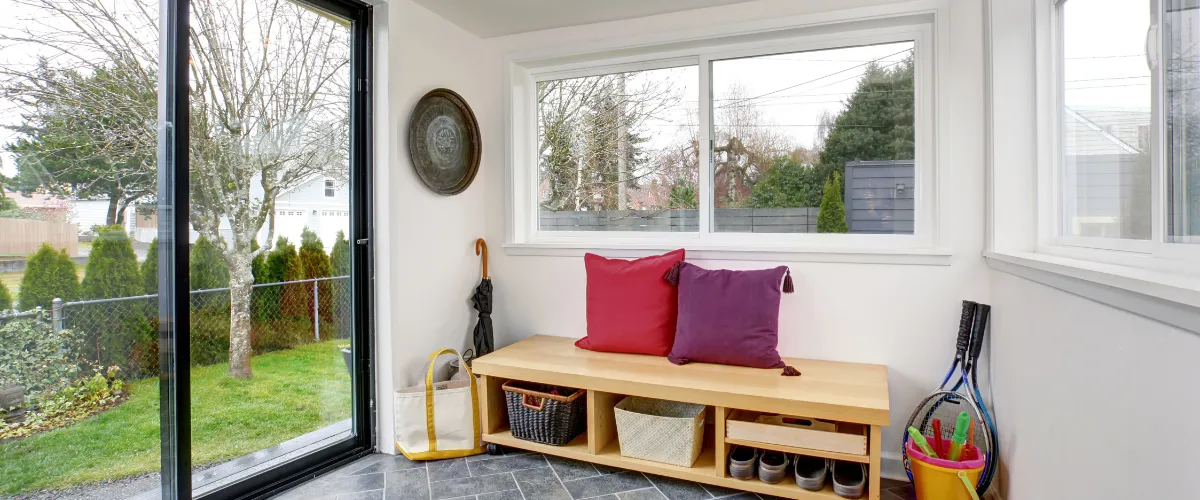 Bright and cozy mudroom with a built-in bench, large windows, and organized storage.