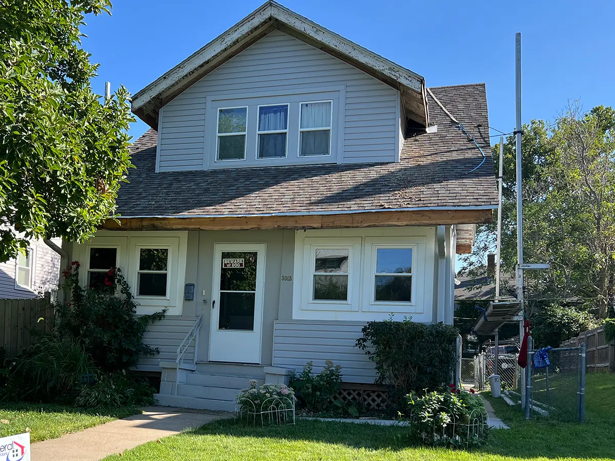 Before photo of the two-story home, showing the worn-out exterior prior to the siding upgrade from HomeGeneral in Nebraska