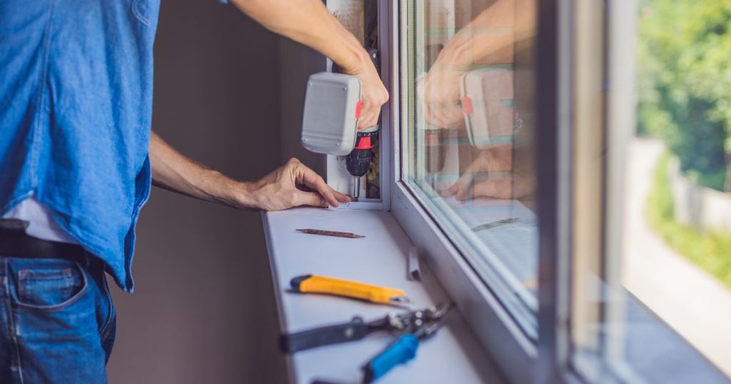 Contractor securing a new window in place with power tools, ensuring a tight and energy-efficient seal.