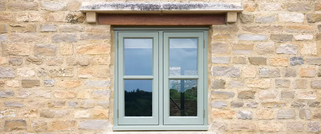 Casement-style replacement windows on a stone historic home in Dundee, Omaha.