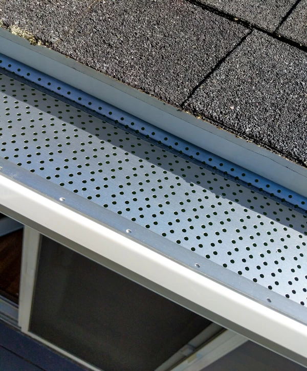 Close-up of a high-quality perforated aluminum gutter guard system installed on a residential roof by a gutter guard installer in Lincoln, NE.